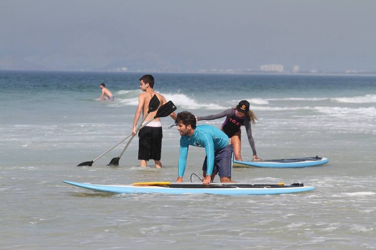 Bruno Gagliasso e Ricardo Pereira praticam stand up paddle na praia da Barra da Tijuca, no Rio