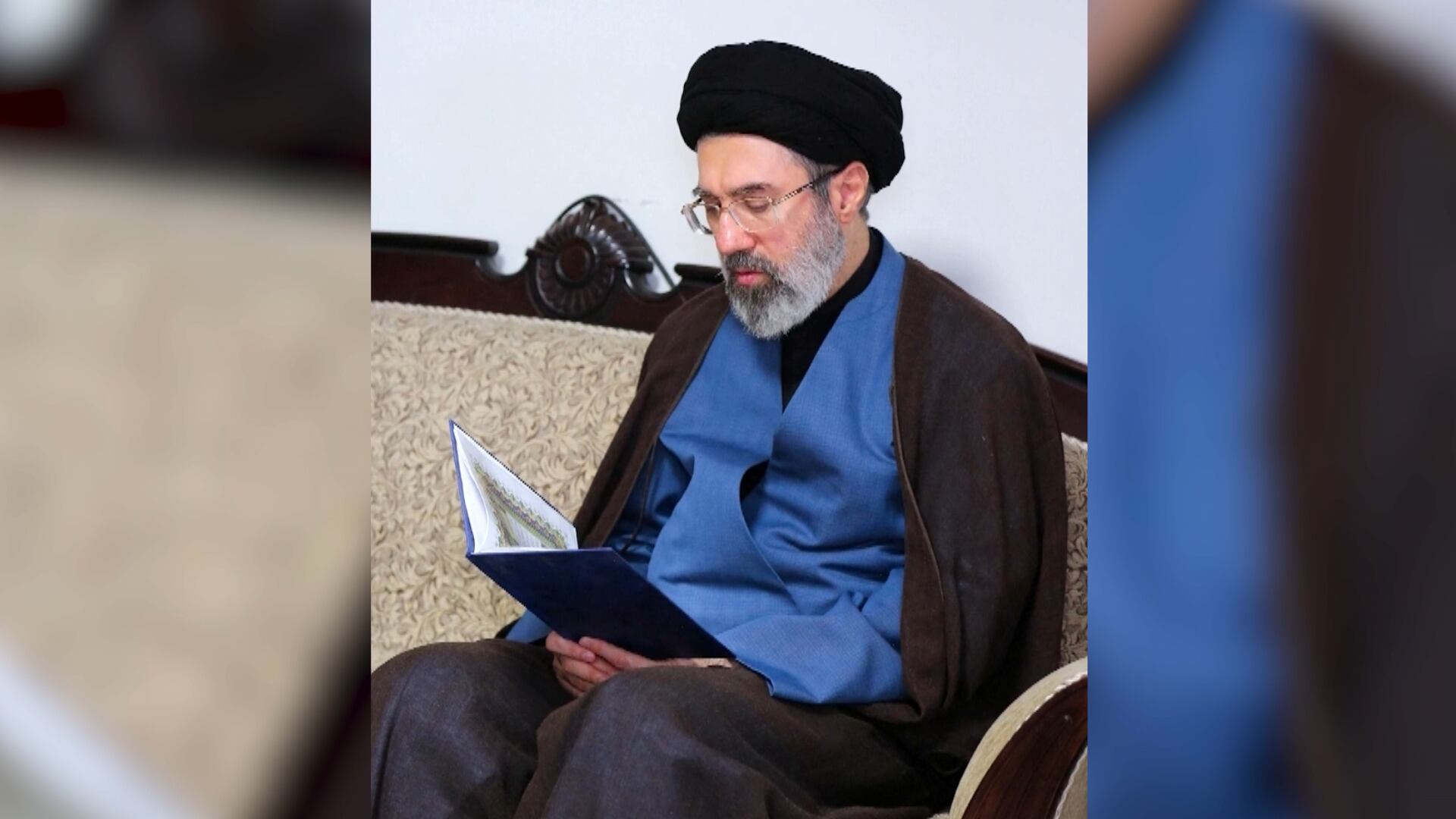 Mojtaba Khamenei, filho de Ali Khamenei, de cabeça baixa lendo um livro
