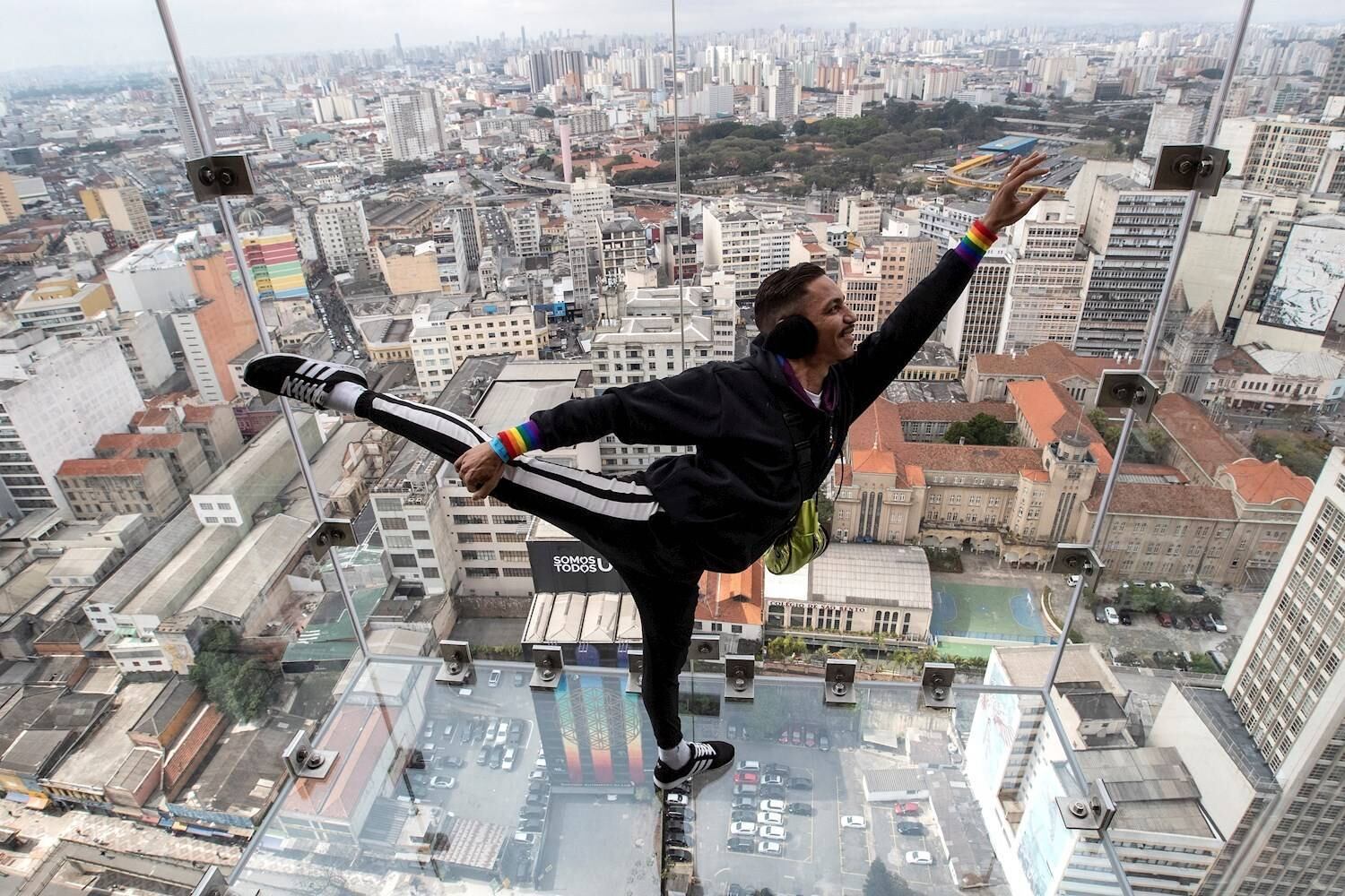 AME7991. SAO PAULO (BRASIL), 11/08/2021.- El bailarín Júnior Alcantara realiza movimiento de baile sobre el piso de vidrio del mirador Sampa Sky hoy, en Sao Paulo (Brasil). El mirador, inaugurado este domingo, está ubicado en una estructura de vidrio a 150 metros de altura en el piso 42 de Mirante do Vale, el edificio más alto de la ciudad de Sao Paulo en Brasil. EFE/ Sebastiao Moreira
