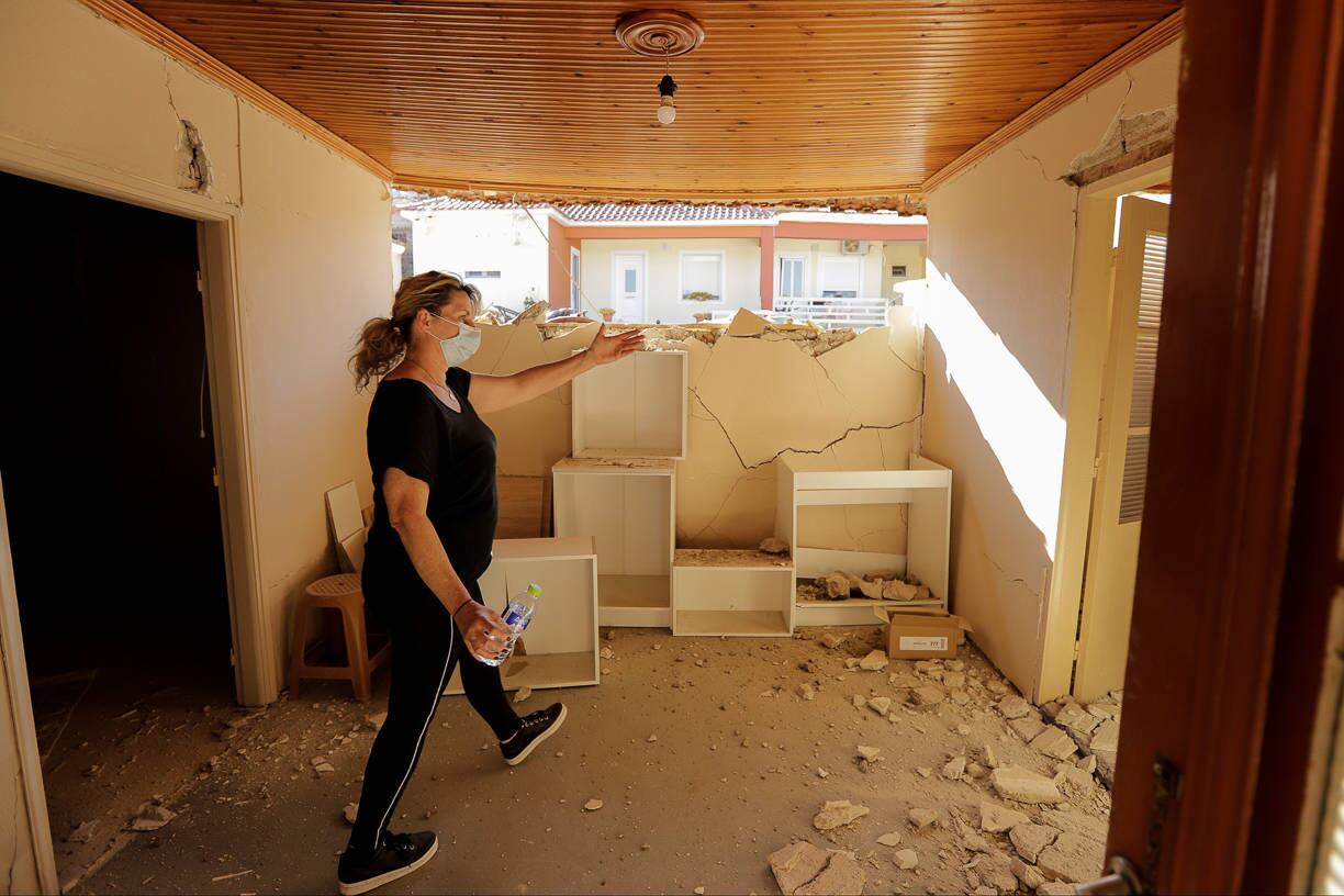 A local resident walks inside her damaged house following an earthquake in the village of Damasi, in central Greece, March 3, 2021. REUTERS/Thanos Floulis