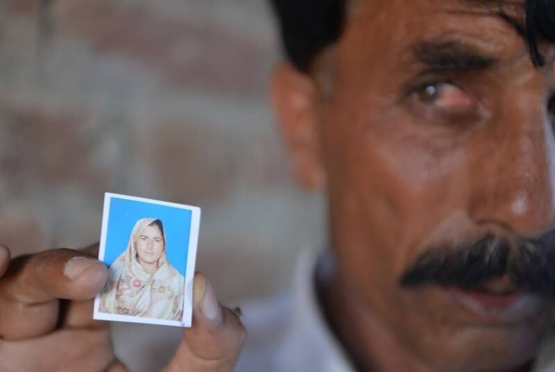 O paquistanês Mohammad Iqbal posa para uma fotografia com uma imagem de sua mulher, Farzana Parveen, que foi apedrejada até a morte por ter se casado por escolha própria