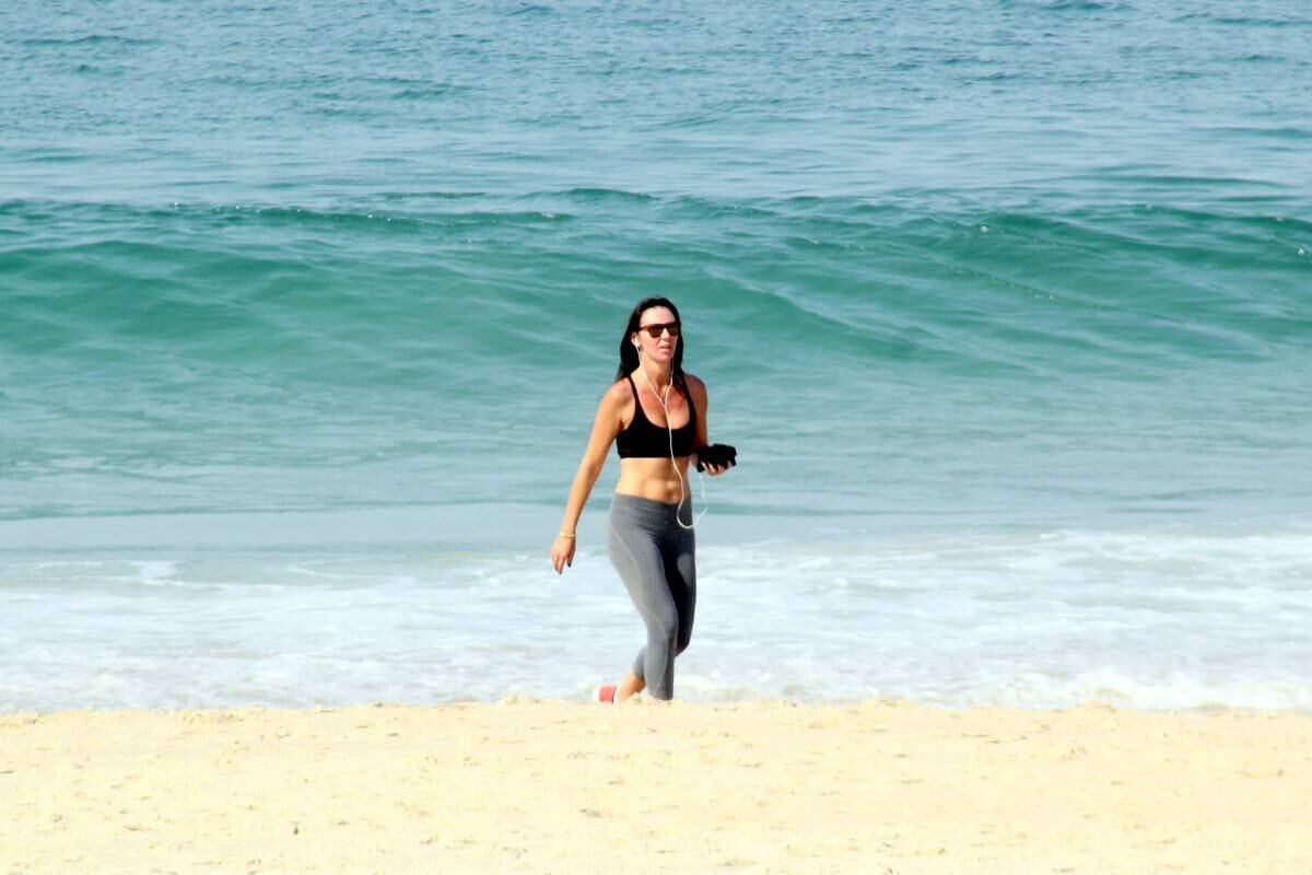 Glenda nem ligou para o sol e caminhou na areia fofa 