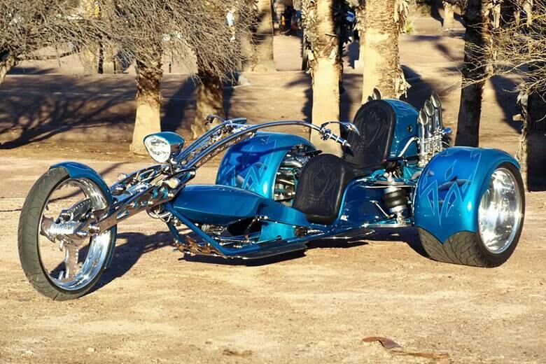 Inteira personalizada, a trike usa rodas traseiras de carro de corrida, com pneus bem largos e extra-finos