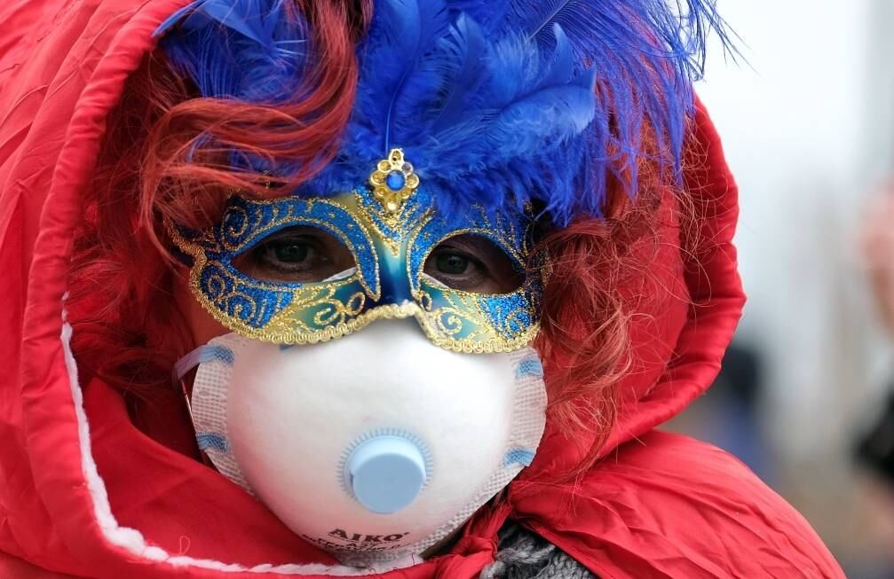 Turista usa máscara cirúrgica durante o carnaval de Veneza por conta do coronavírus