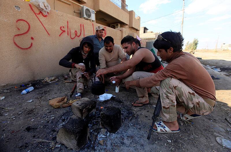 Soldados iraquianos param para tomar chá em Qaraqosh, perto de Mosul, nesta quarta-feira (2). Forças iraquianas avançam contra as bases do Estado Islâmico no local