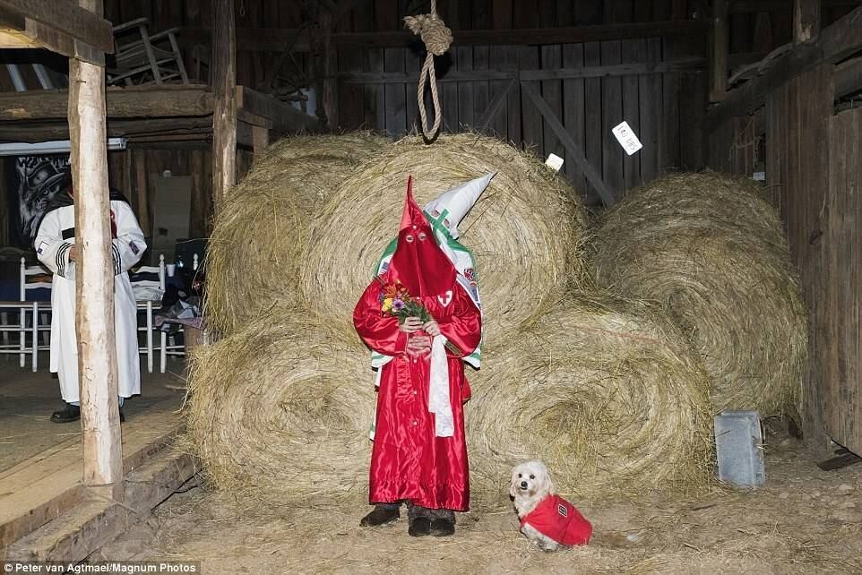 Em meio aos mantos brancos encapuzados, se destaca uma pessoa vestida totalmente de vermelho, também com o rosto coberto — além de um cachorro, que acompanha toda a cerimônia. Trata-se de um casamento entre dois membros da seita racista KKK (Ku Klux Klan)