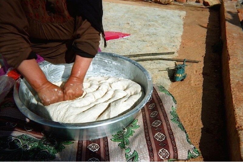 Uma idoso amassa a massa de pão em um assentamento, no Vale do Bekaa. Ela foi fotografada por Bashar, de 12 anos