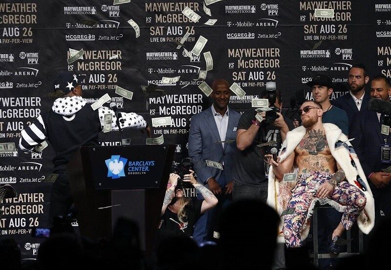Em uma delas, Mcgregor acusou Floyd de estar ficando pobre, porque o lutador enfrenta problemas com a justiça americana. O pugilista então decidiu fazer uma chuva de dinheiro