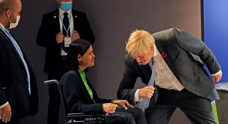 Boris Johnson (à dir.) cumprimenta de maneira desajeitada Karine Elharrar (à esq.)