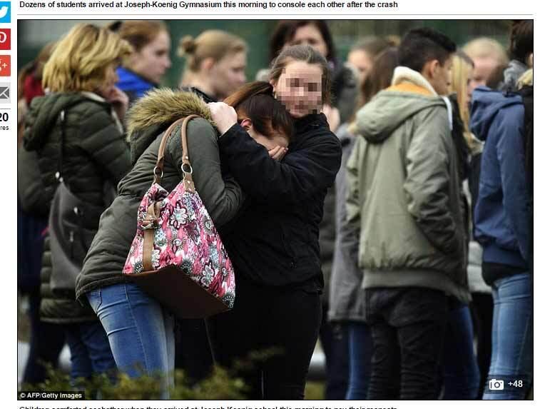 Duas jovens se abraçam em busca de conforto, durante cerimônia de homenagem às vítimas
