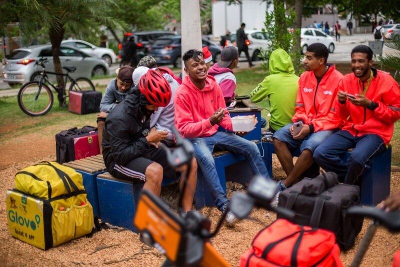 Entregadores reúnem-se em praças, onde esperam a hora do almoço e do jantar