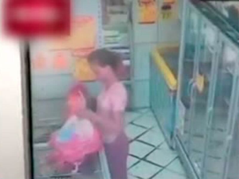 Enquanto a mulher furta os produtos, um homem dá cobertura