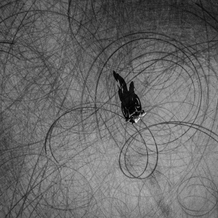 Um motociclista fazendo desenhos com marcas de pneu no chão de um estacionamento em Trakai, na Lituânia