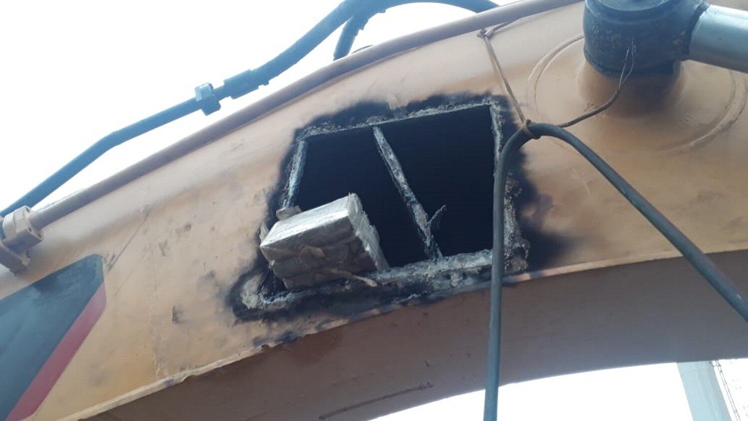 Em uma delas, cortou-se uma abertura na parte lateral do braço do acionamento da caçamba, por meio da qual foram localizados e retirados dezenas de tabletes envoltos em material plástico, totalizando 158 kg de cocaína
