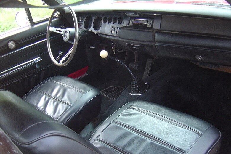 Os bancos são em couro e a comprida alavanca e câmbio fica próxima ao volante de três raios