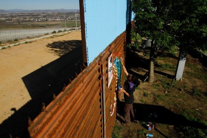 A foto tirada no sábado (28 de janeiro) mostra um grafiteiro fazendo um cartum no muro presente na cidade de Tijuana. A região é conhecida como um dos destinos preferidos dos americanos para fazer turismo no México. 