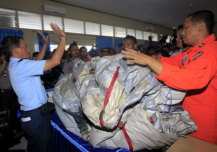 Comandante Dwi Putranto (esquerda) verifica tobogã de emergência do avião da AirAsia nesta terça-feira (30)
