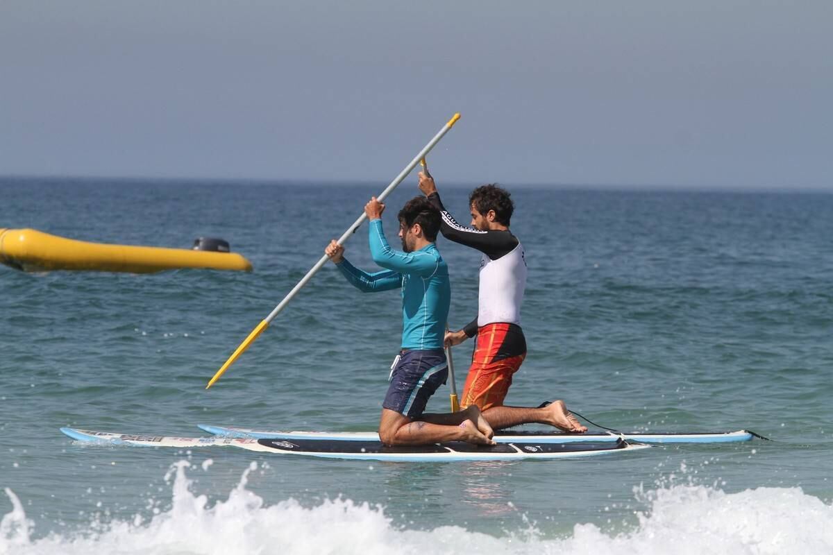 Bruno Gagliasso e Ricardo Pereira praticam stand up paddle na praia da Barra da Tijuca, no Rio