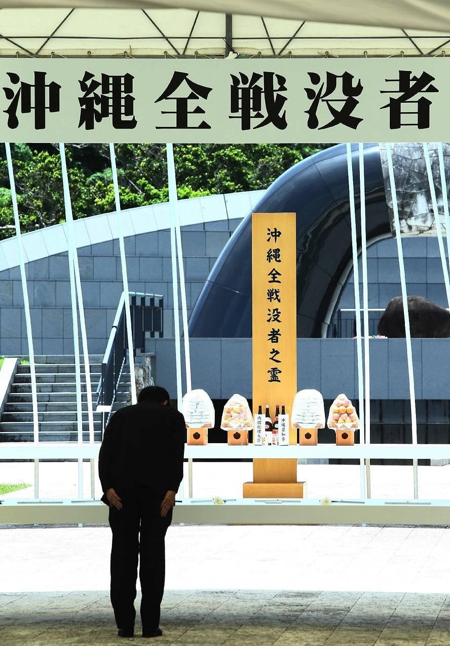 O primeiro-ministro do Japão, Shinzo Abe se curva diante do memorial construído para relembrar o país do 69º aniversário da Batalha de Okinawa, o maior confronto marítimo, terrestre e aéreo da história, que aconteceu em 1945 
