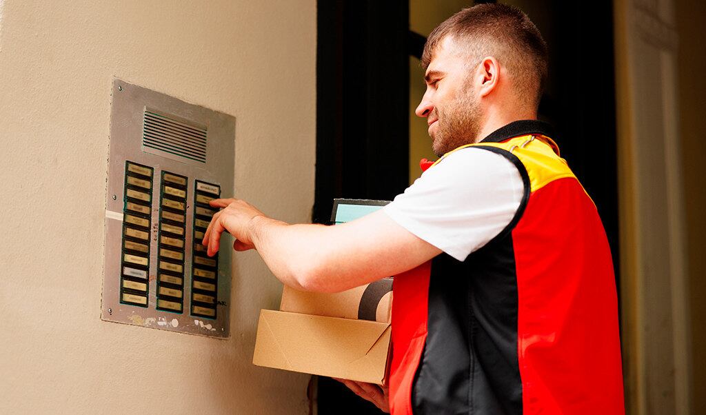 Entregador de aplicativo de comida (iFood) toca interfone ao chegar em edifício. Reprodução / iFood News (https://www.news.ifood.com.br/)