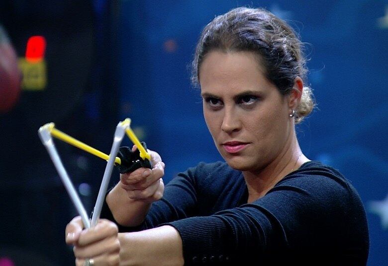 Em seguida, a mulher
entra em cada estação, responde à pergunta e mira em um casal