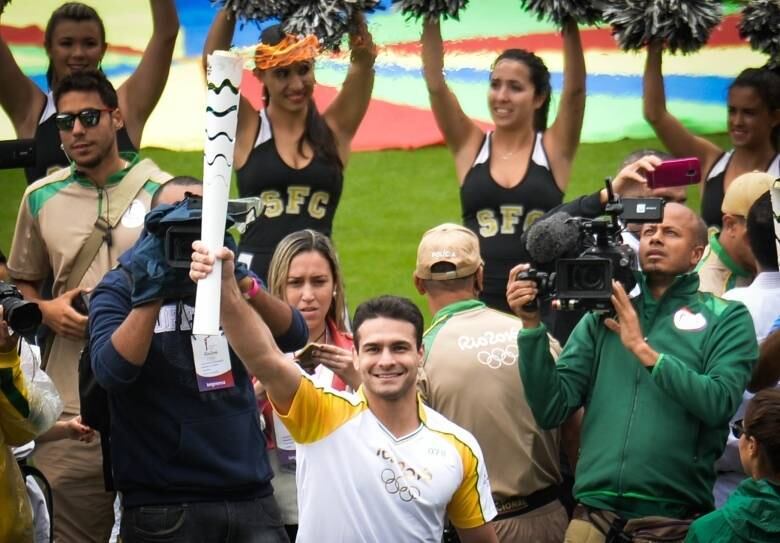 O atleta percorreu o gramado da Vila Belmiro com o símbolo olímpico empunhado