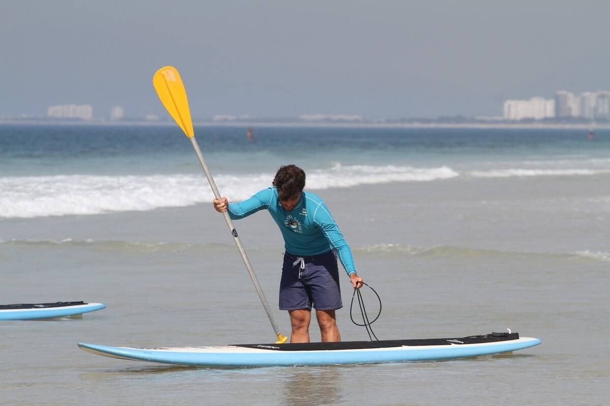 Bruno Gagliasso e Ricardo Pereira praticam stand up paddle na praia da Barra da Tijuca, no Rio