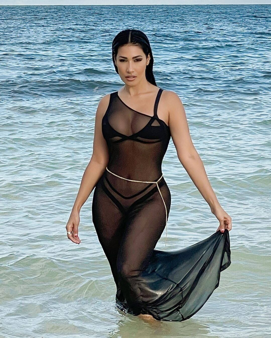 Nas gravações, ela também posou no mar com o mesmo biquíni preto, mas com uma saída de praia preta transparente e uma corrente de cintura por cima
