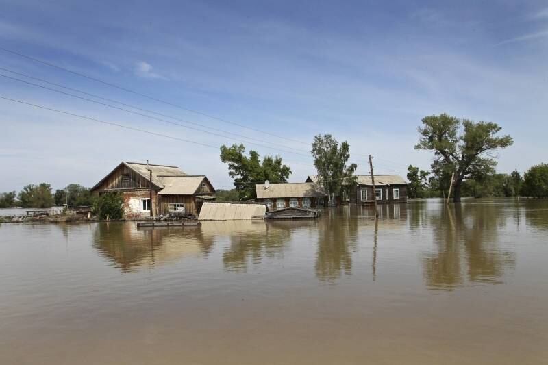 Casas em Ust-Charish, na Rússia,
ficam rodeadas de água após fortes enchentes atingirem a região