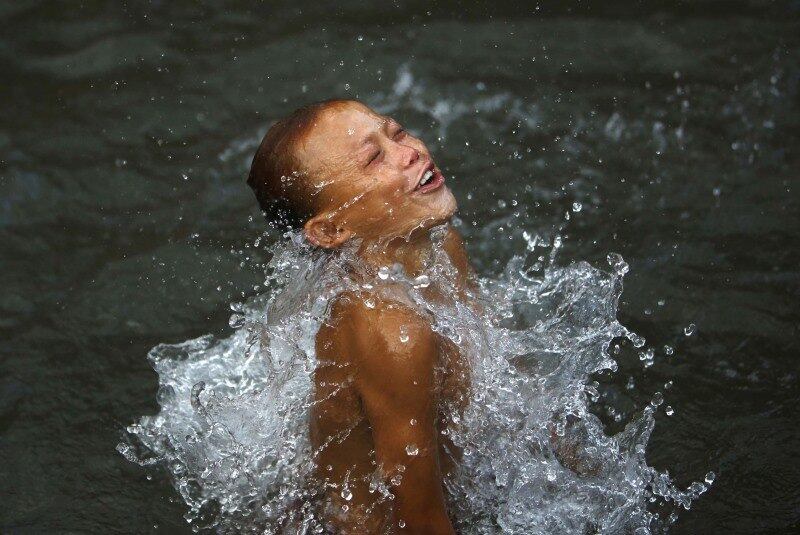 Menino nada em lago em Lalitpur, no
Nepal