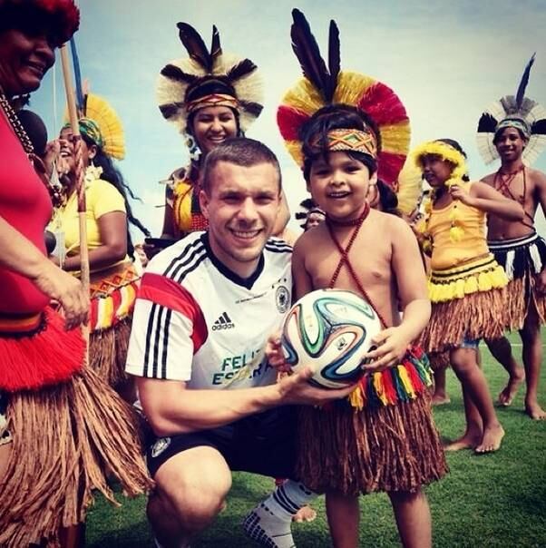 Lukas Podolski posa com um pequeno índio pataxó