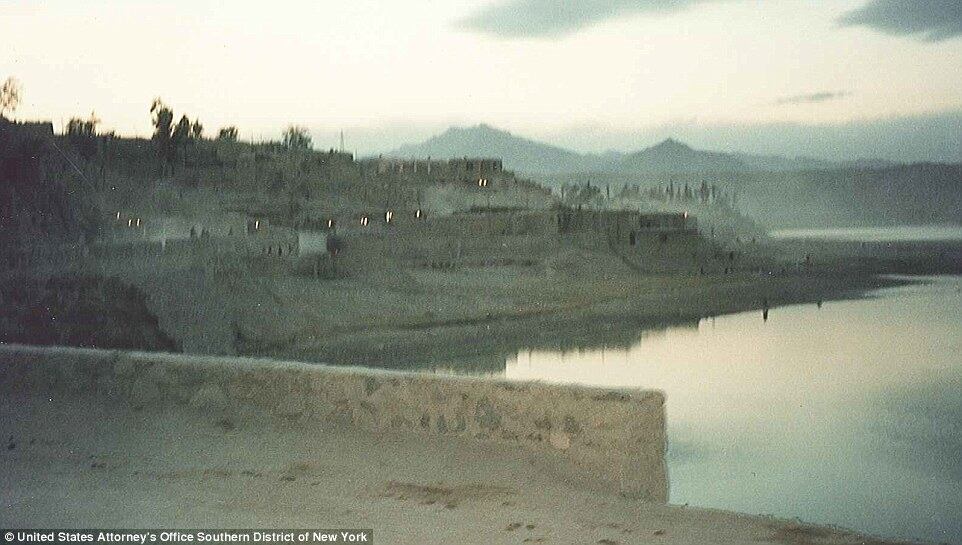 Um lago cerca algumas montanhas e as cabanas dos habitantes quase não mostravam luzes ao entardecer