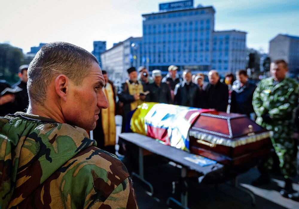 Membros das forças aparecem ao lado de um caixão durante o funeral de um militar não identificado, morto durante os confrontos recentes em Kiev, na Ucrânia