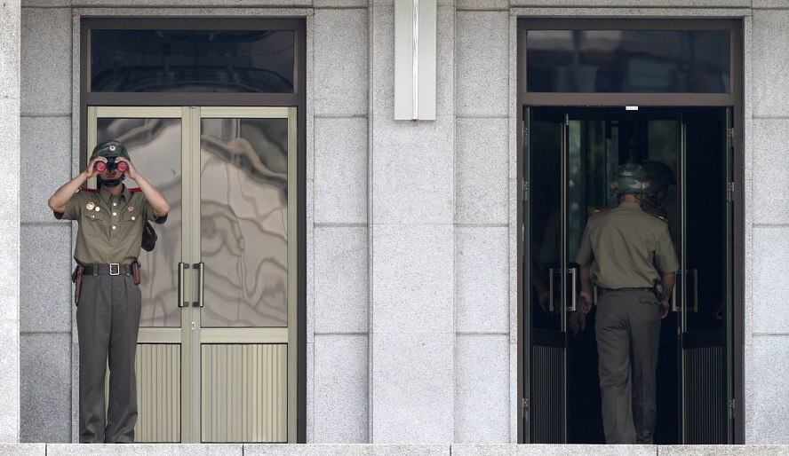 Um soldado da Coreia do Norte olha, através de um binóculo, para a fronteira com a vizinha Coreia do Sul