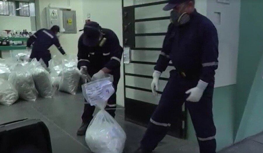 Policiais pesam sacos com drogas antes da incineração
