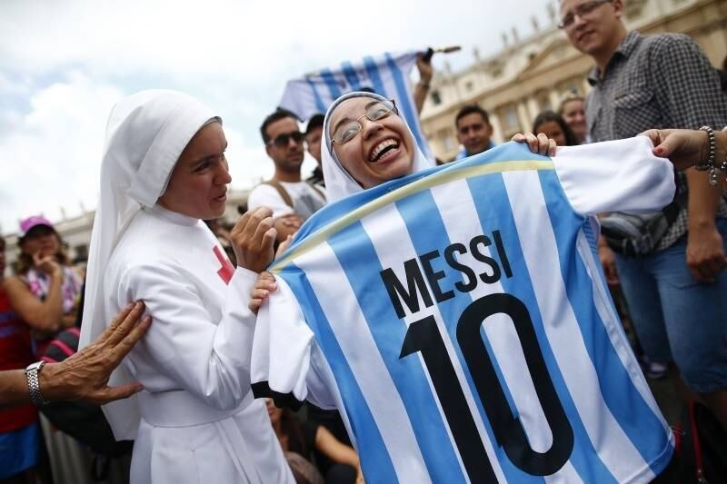 Freira segura um uniforme
da seleção argentina enquanto espera pela missa de domingo do Papa Francisco na
Praça de São Pedro, no Vaticano