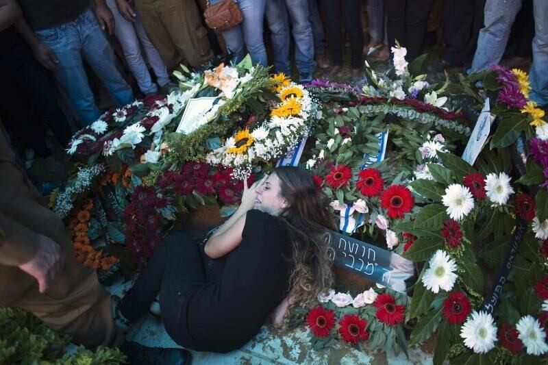 A namorada do soldado
israelense Tal
Yifrah, morto durante a ofensiva
militar na faixa de Gaza, chora em cima do caixão durante funeral em Rishon Lezion, Israel