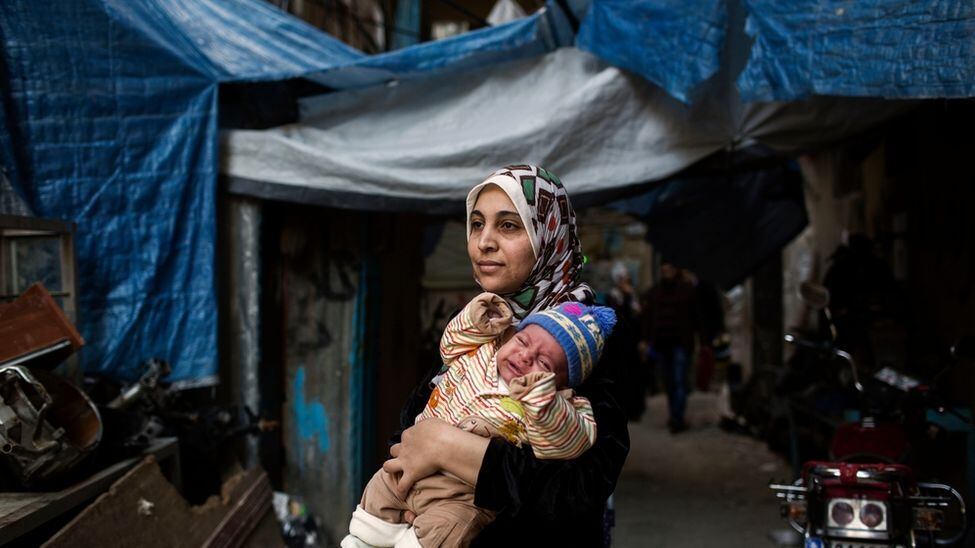 Iman,
mãe de quatro filhos, carrega um de seus bebês na porta da unidade de
maternidade do MSF (Médicos Sem Fronteiras), no campo de Shatila. 

Ela já vivia
como refugiada no Líbano há três anos, depois de fugir da guerra da Síria. Ela
regularmente vai para a maternidade para verificar e acompanhar a saúde do
bebê. “Não temos nada. Meu marido não tem trabalho estável e lutamos cada mês
para sobreviver”, disse Iman ao El Diario