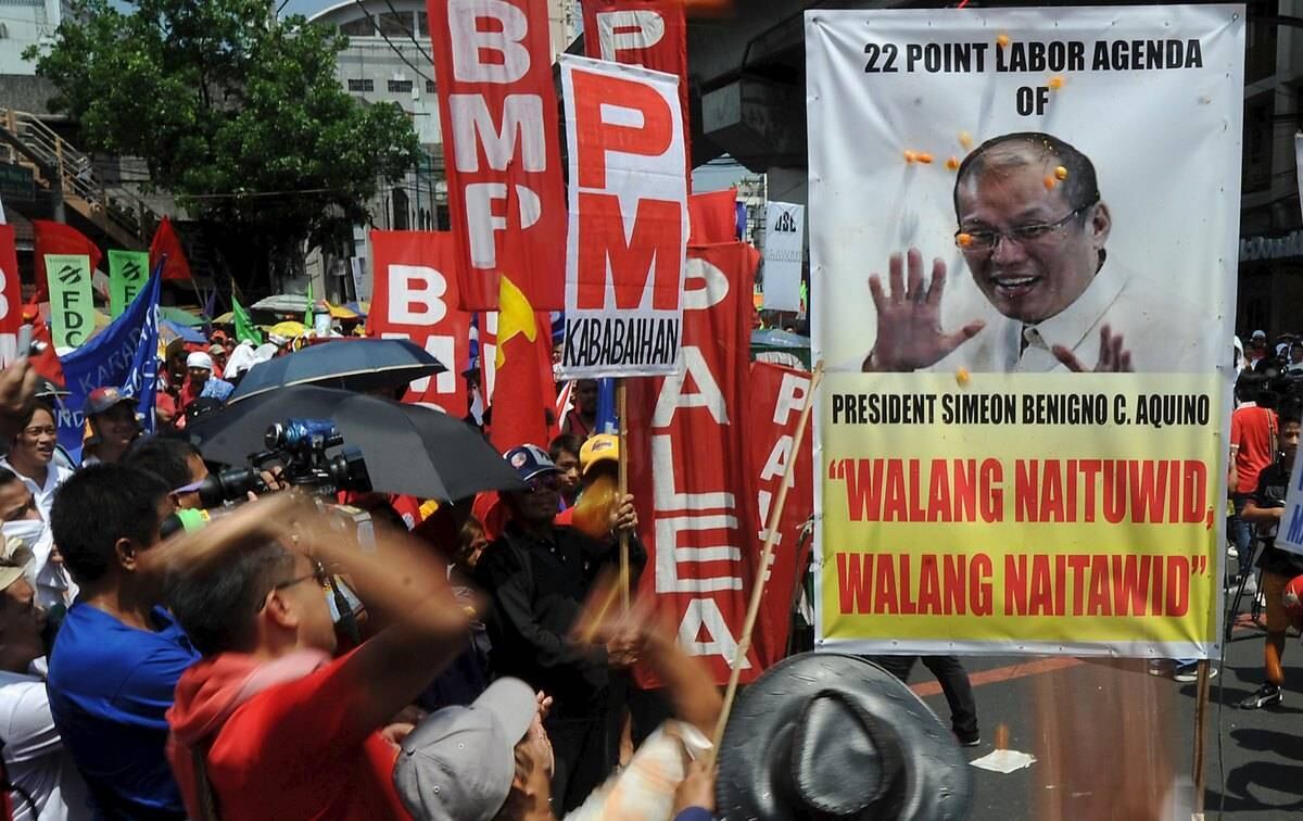 Nas Filipinas, trabalhadores atiram tomates contra um
pôster do presidente Benigno Aquino do lado de fora do palácio presidencial, em
Manila. Escritas no cartaz, as frases "não há caminho reto" e
"nossas vidas não melhoraram" em referência à administração de Aquino 
