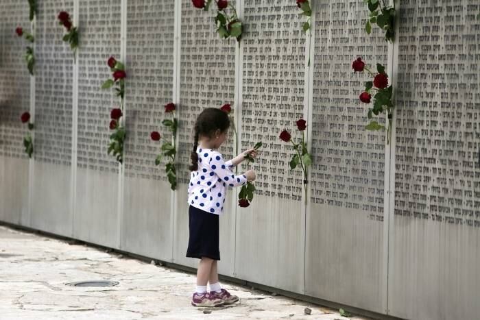 Menina israelense segura
uma rosa em um memorial com nomes de soldados mortos durante o Dia da Memória,
em Latrun, perto de Jerusalém