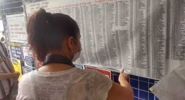 Candidata olha nome na lista de sala de prova para a segunda fase da Fuvest