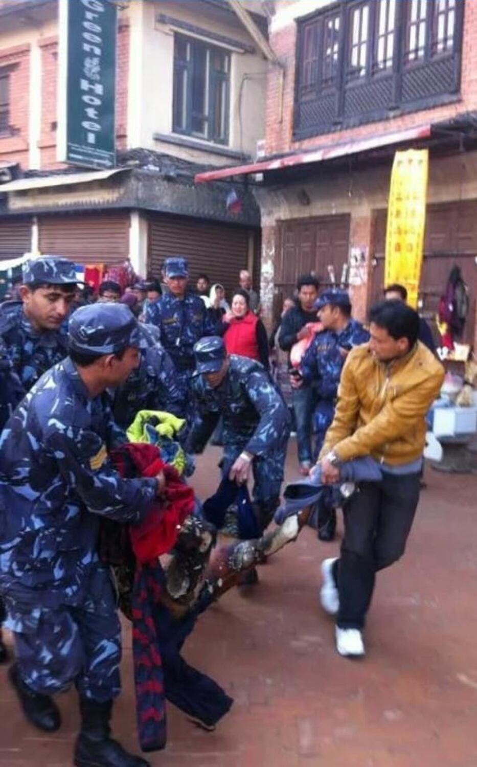 Na imagem acima, policiais e moradores carregam o monge tibetano para o hospital. Ele está em estado grave