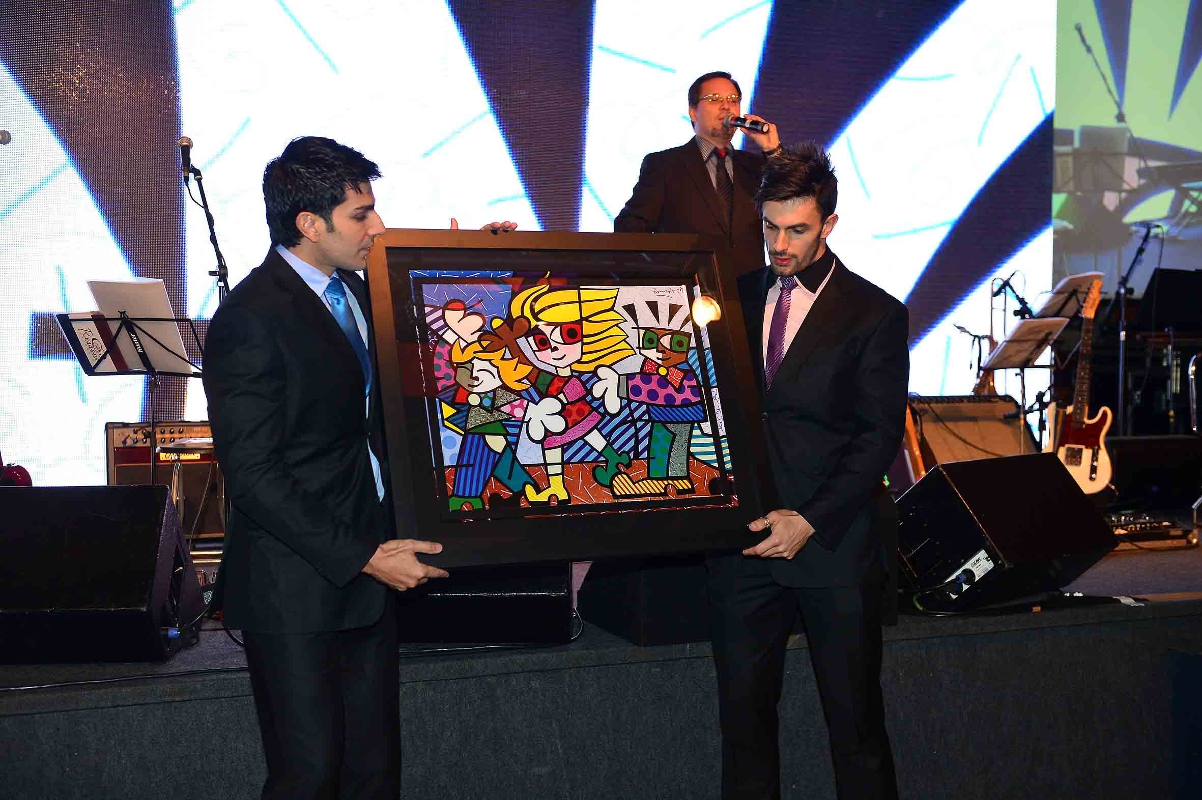 Os assistentes de palco de Rodrigo Faro no Melhor do Brasil, Dênis e Paulão, apresentaram as obras de arte aos convidados. A obra Britto Kids, do artista plástico Romero Brito, foi vendida por R$ 18 mil
