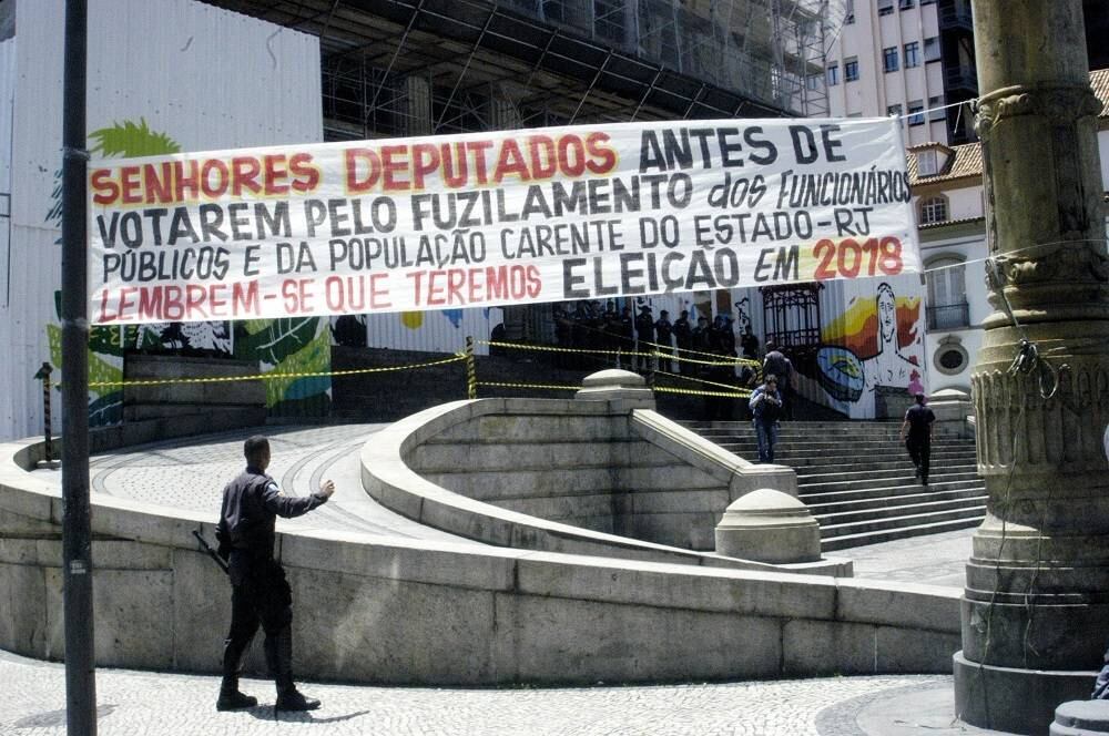Servidores exibem faixa com mensagem para deputados sobre medidas que afetarão os funcionários públicos e alertam para o próximo pleito em 2018. A ocupação da Alerj ocorre em um ano marcado por falta de verbas para a saúde pública, fechamento de unidades hospitalares, atrasos recorrentes de salários, congelamento de contas, entre outros problemas