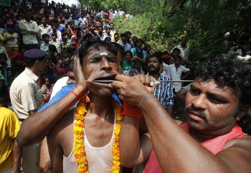 Devoto hindu tem suas bochechas perfuradas
durante procissão religiosa chamada "Shitla Mata" na cidade de Chandigarh,
na Índia