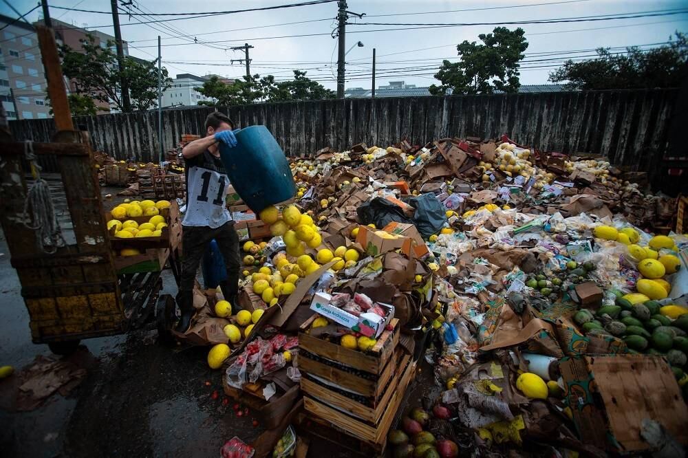 Comerciante joga fora alimentos estragados