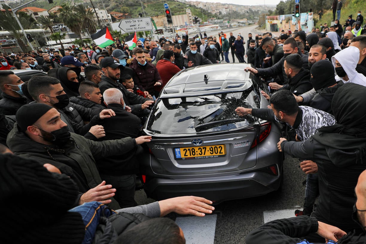 An Arab Israeli protester breaks the window of a passing car during a protest against a wave of violence in their communities, where they say police have turned a blind eye to crime, in northern town of Umm el Fahm, Israel March 12, 2021. REUTERS/Ammar Awad TPX IMAGES OF THE DAY