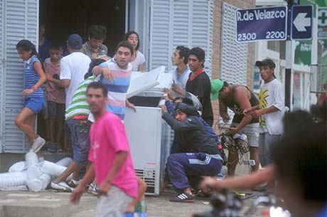 Pessoas carregam freezer durante saque ontem em Tucumán