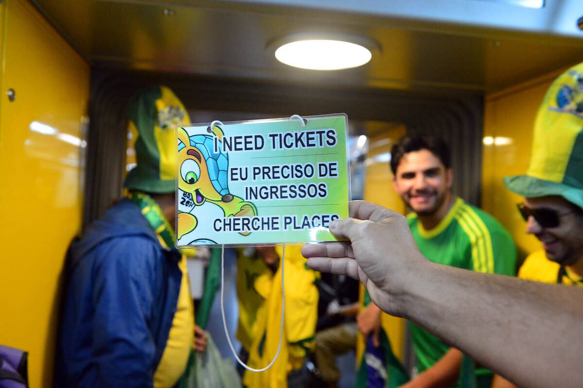 Torcedores se desdobram para conseguir ingressos da abertura da Copa. Esse da foto tentava comprar ingressos em três idiomas distintos