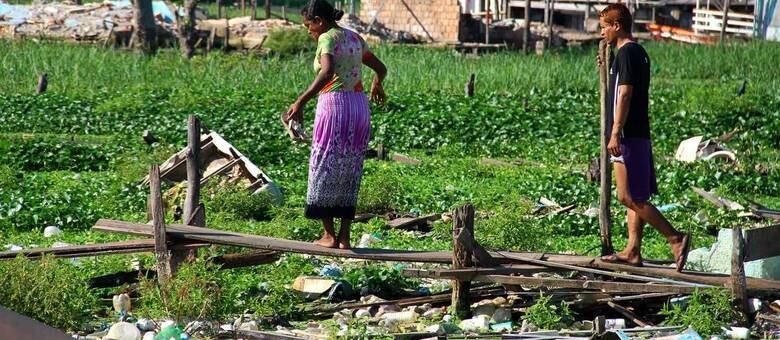 Moradores caminham no meio do lixo em bairro de Manaus